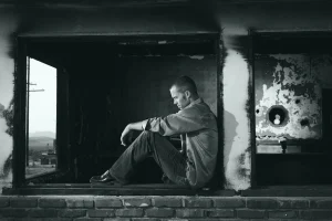 Grayscale photo of man sitting